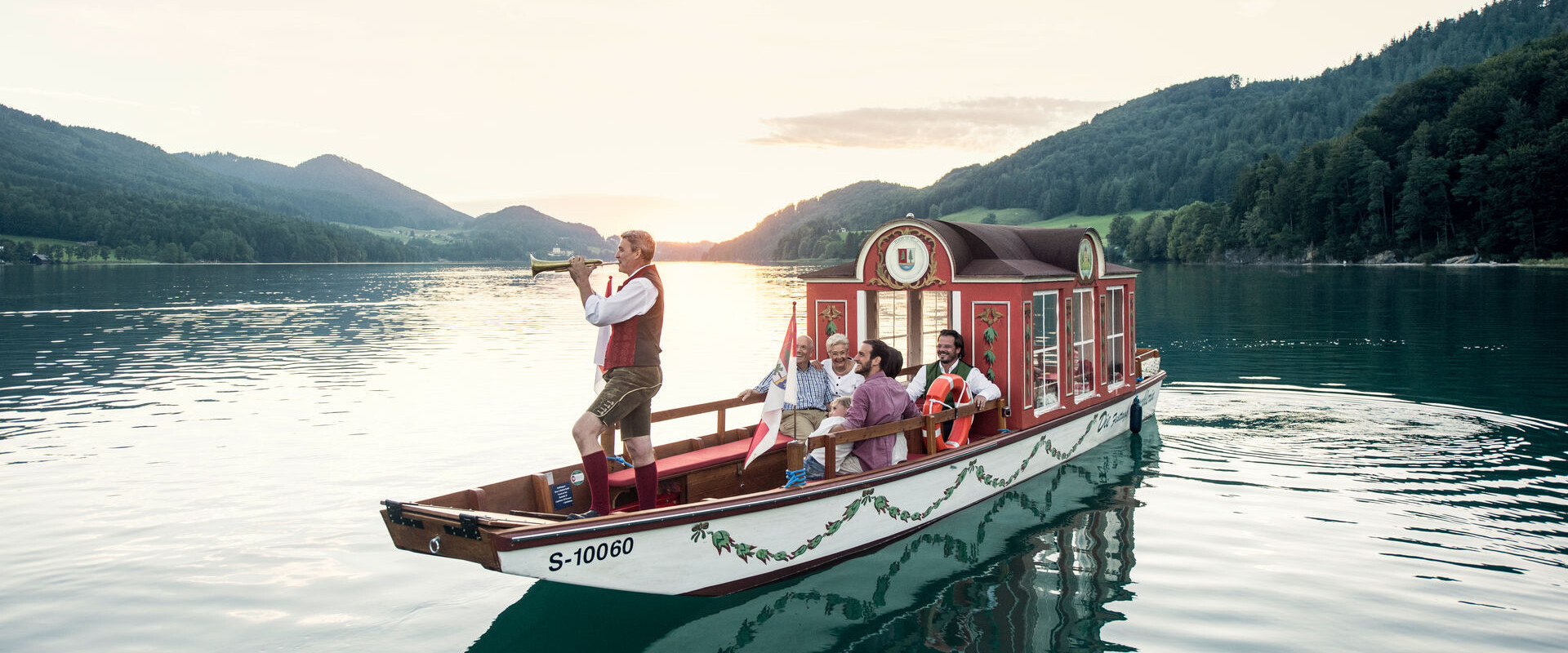 Eine Zille mit Bläser am Fuschlsee, Salzkammergut.