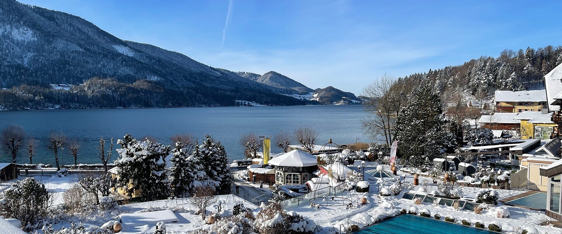Das 4* Superior Waldhof Fuschlsee Resort mit Schnee und Außenpool.