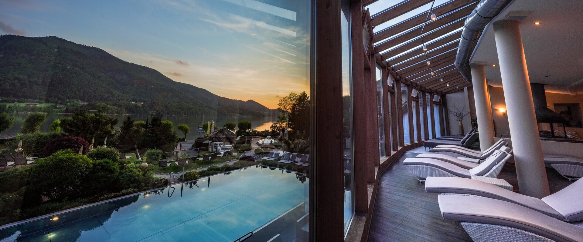 Eine Dame genießt die Ruhe und den Parnoramablick auf den Fuschlsee im Ruheraum des Spa im Hotel Ebner's Waldhof.