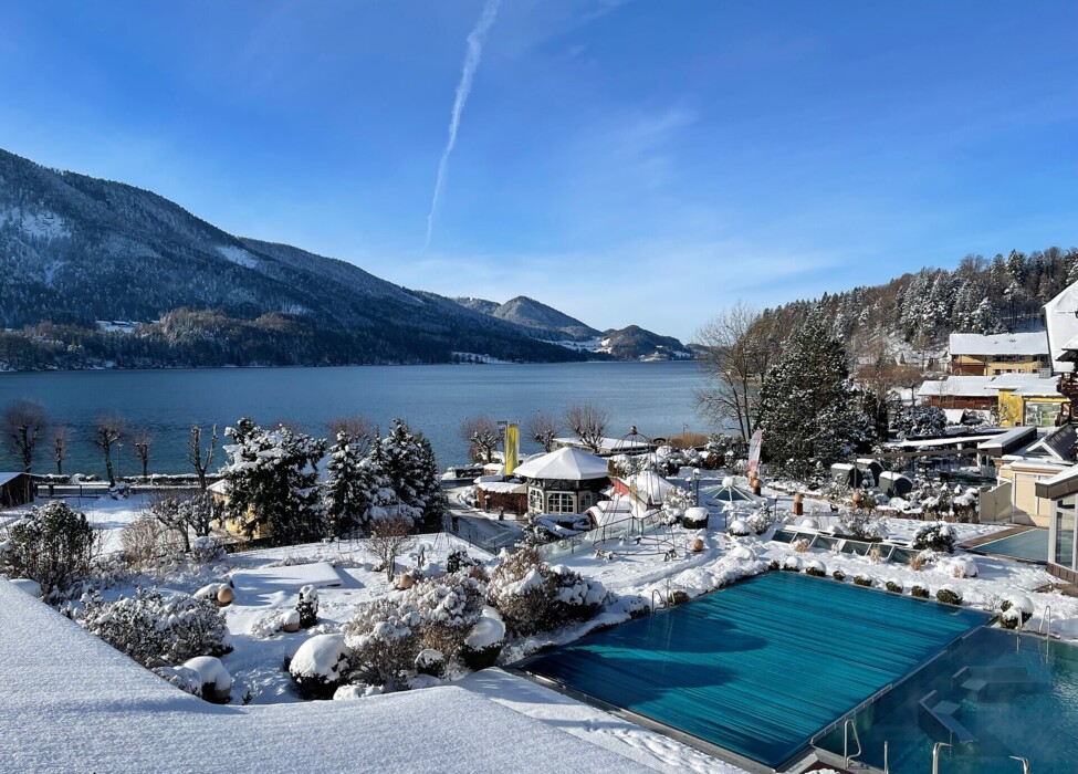 Das 4* Superior Waldhof Fuschlsee Resort mit Schnee und Außenpool.