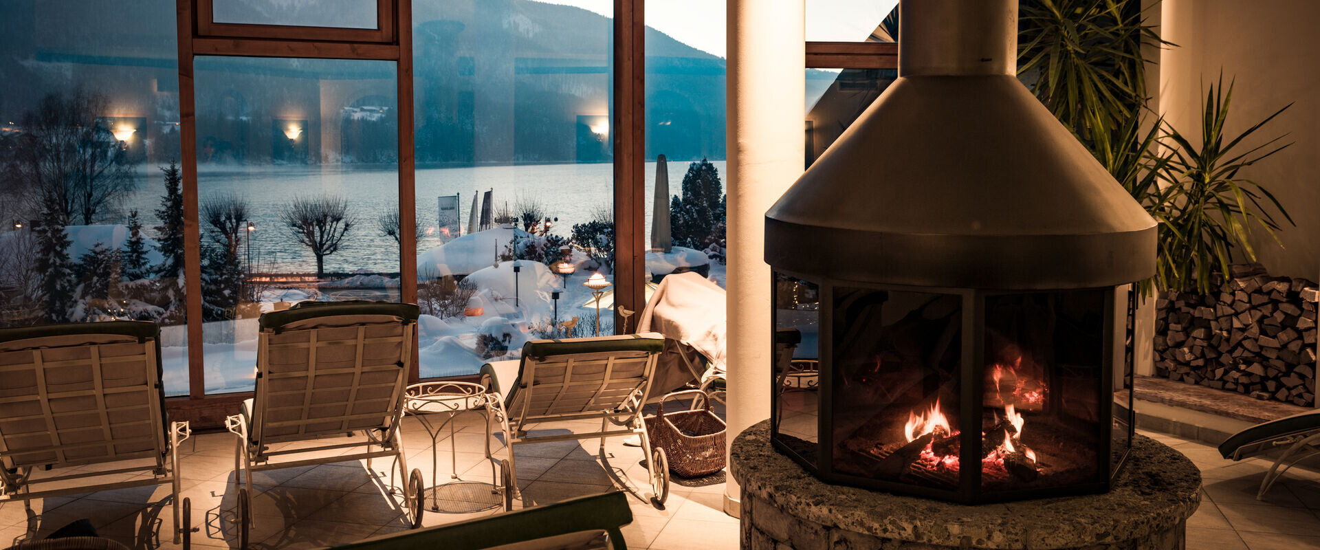 Der Ruheraum mit Panoramablick auf den winterlichen Fuschlsee im Wellnesshotel Ebner's Waldhof am See.