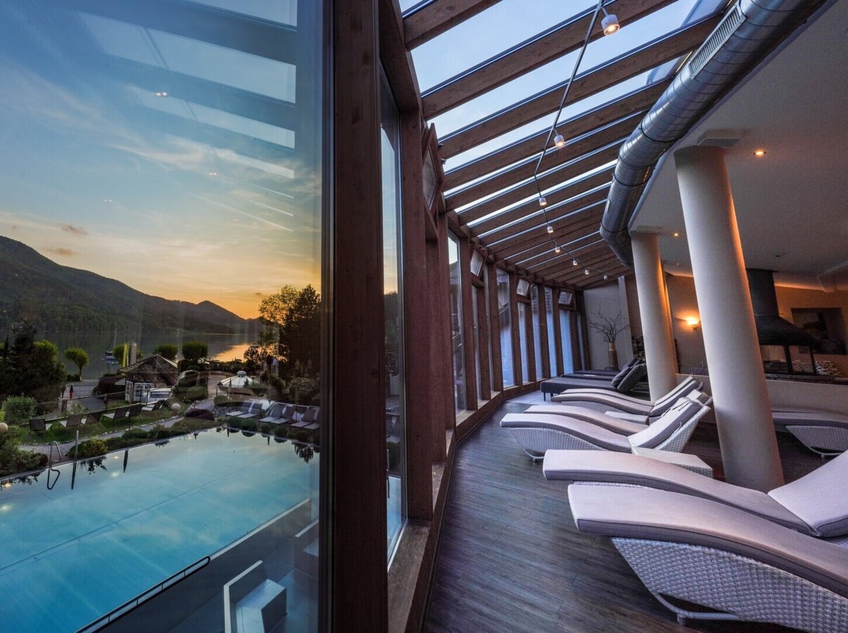 Blick aus dem Ruheraum auf den Pool bei Sonnenuntergang.