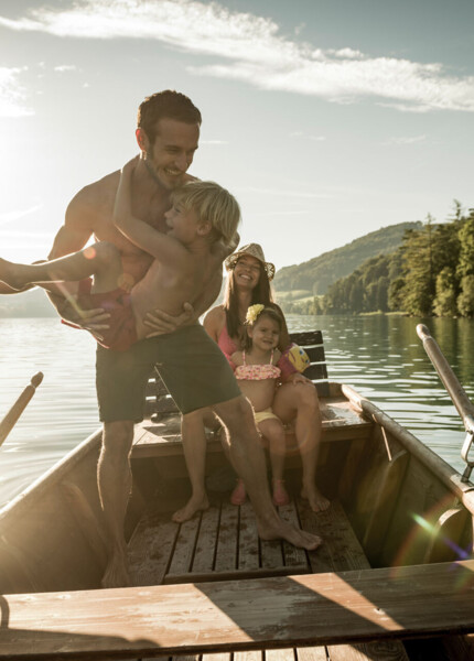 Familie in einem Ruderboot am Fuschlsee, Salzkammergut.