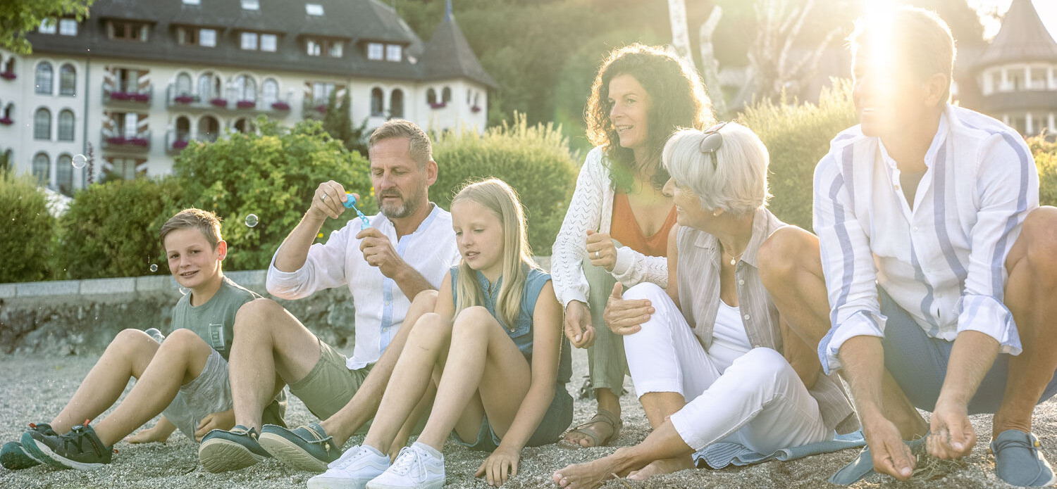 Kinder mit Schlitten beim Spielen im Tiefschnee auf der Waldhofalm am Fuschlsee.