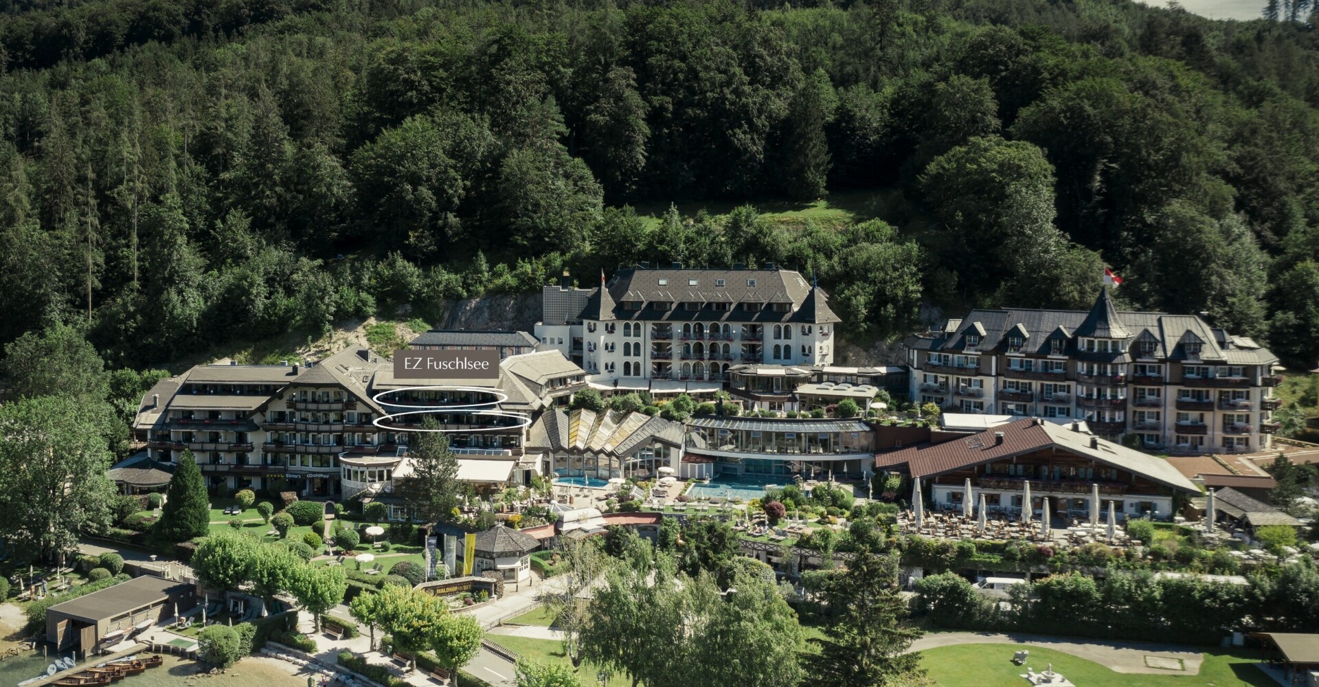 Aerial view of Waldhof Fuschlsee Resort with surrounding greenery and lakefront.