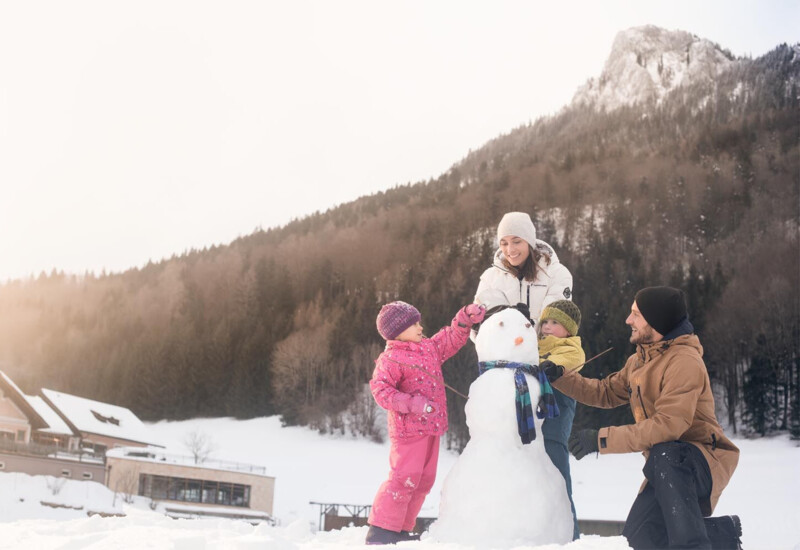 Familie mit Kind am privaten Badestrand des Familienhotels Waldhof Fuschlsee Resort, Salzkammergut.