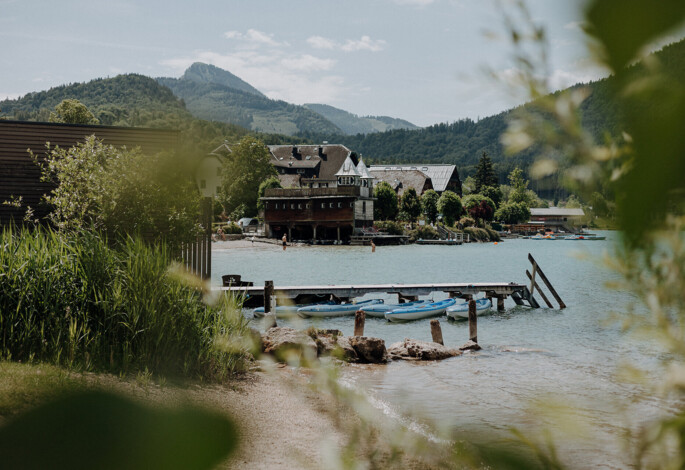 Kinder mit Tubing-Reifen auf dem Förderband im Familienurlaub am Fuschlsee.