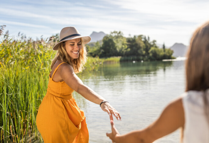 Junge Dame in gelben Sommerkleid am Ufer des Fuschlsee.