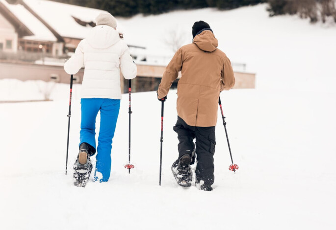 Schneeschuhwanderer auf der tief verschneiten Waldhofalm am Fuschlsee.