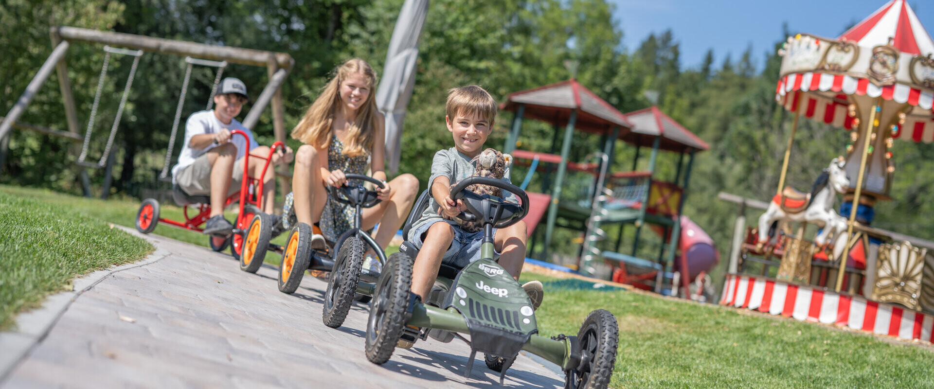 Kinder mit Go-Karts im Familienhotel Waldhof Fuschlsee Resort.