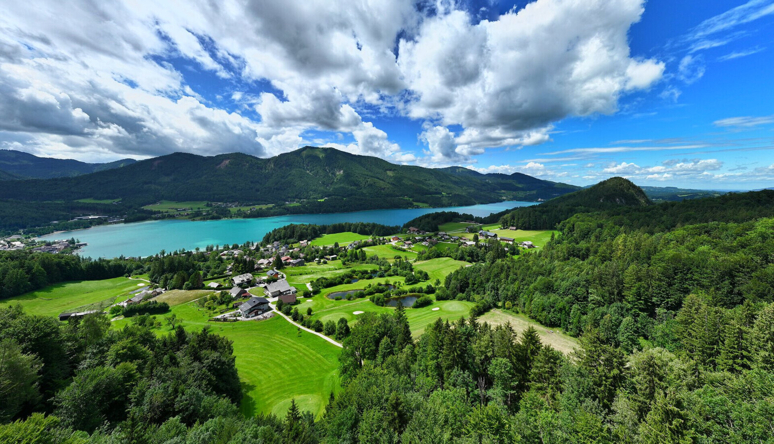 Urlaub im Golfhotel am Fuschlsee. Pärchen mit Golf-Trolly am Golfplatz.