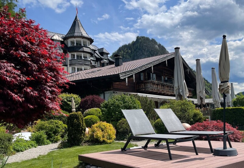 Der großzügige Garten mit Liegemöglichkeiten im Sommer mit Blick auf das Hotel Ebner's Waldhof am Ufer des Fuschlsee.