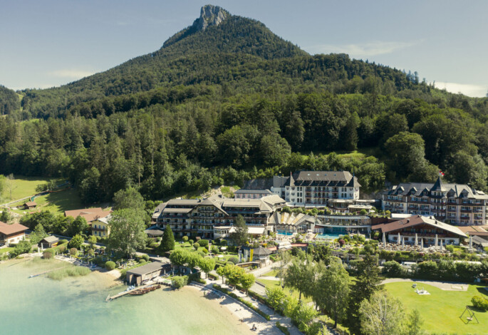 Panoramablick auf das Familienhotel Ebner's Waldhof am See im Sommer.