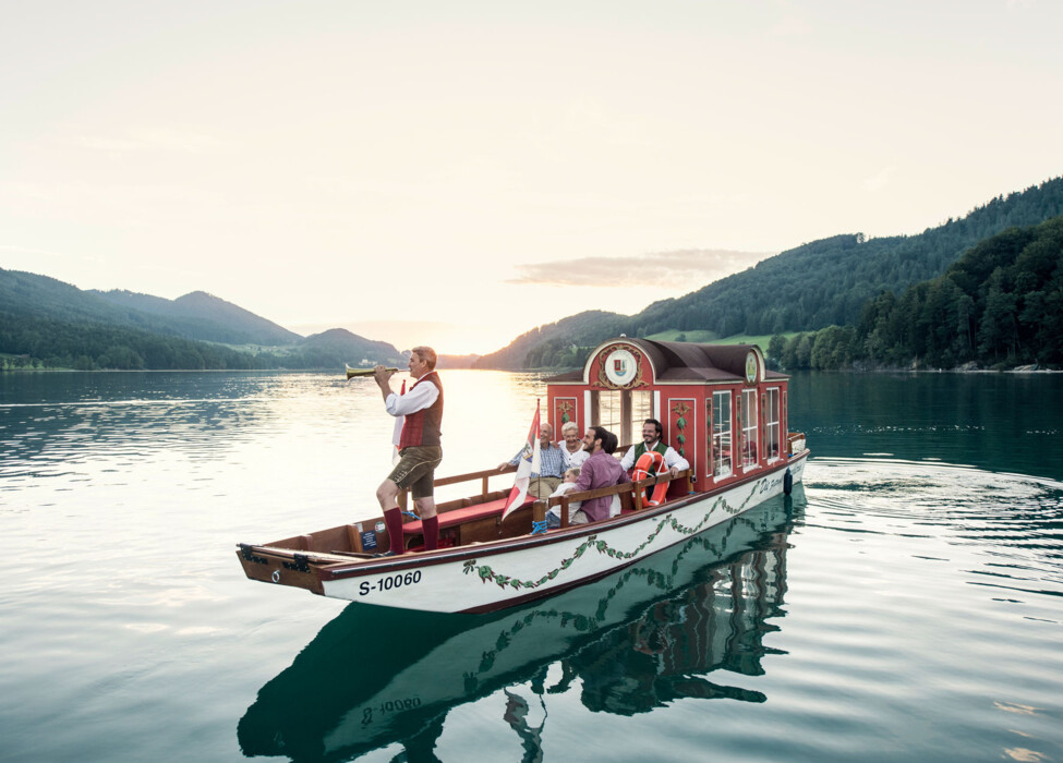 Eine Zille mit Bläser am Fuschlsee, Salzkammergut.