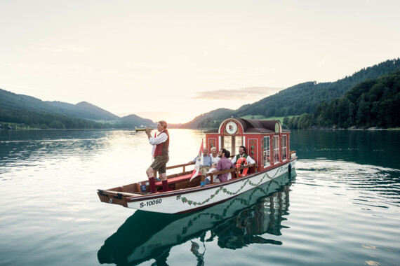 Eine Zille mit Bläser am Fuschlsee, Salzkammergut.