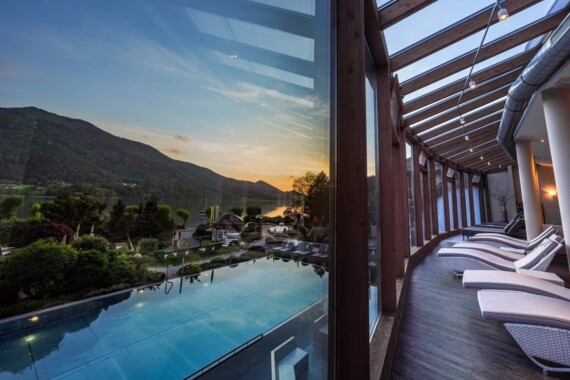 Außenpool des 4*S Wellnesshotel Waldhof Fuschlsee Resort bei Sonnenuntergang.