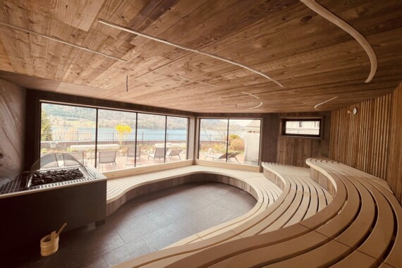 Wellness pur im Wellnesshotel Ebner's Waldhof am Fuschlsee. Pärchen beim Aufguss in der Sauna.