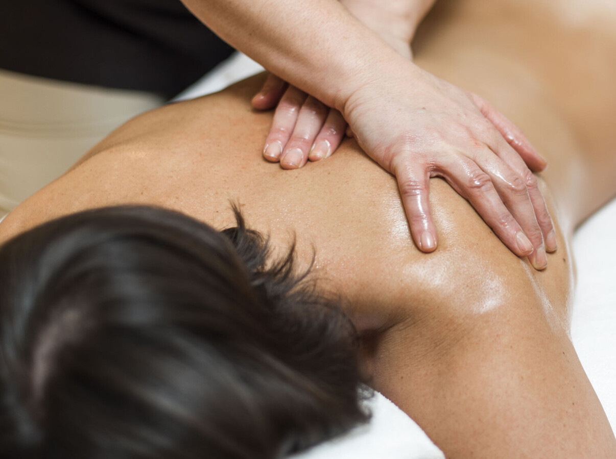 Person receiving a back massage, promoting relaxation and wellness.