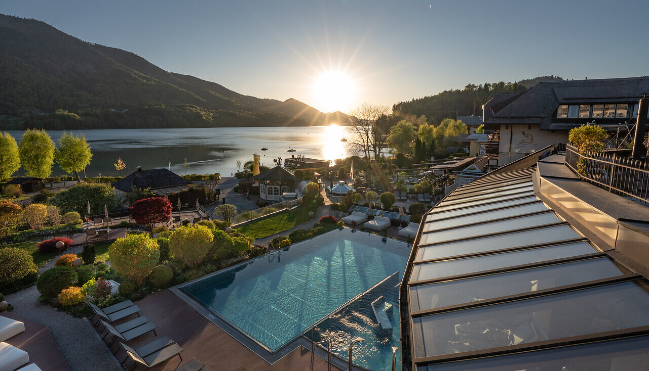 Junges Pärchen im Außenpool des Hotel Waldhof Fuschlsee Resort im romantischen Wellnessurlaub am Fuschlsee.