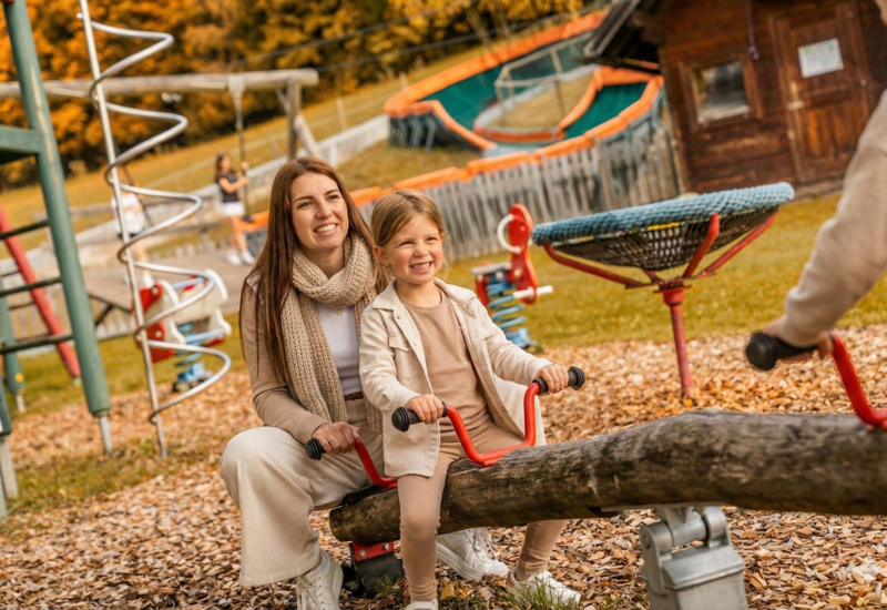 Familie mit Kind am privaten Badestrand des Familienhotels Waldhof Fuschlsee Resort, Salzkammergut.