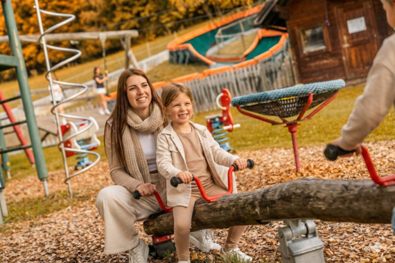 Familie mit Kind am privaten Badestrand des Familienhotels Waldhof Fuschlsee Resort, Salzkammergut.
