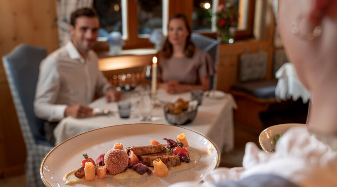 Babymoon mit kulinarischem Genuss - Pärchen auf der Terrasse beim Abendessen im Waldhof Fuschlsee Resort.